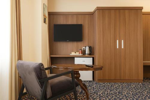 a hotel room with a table and a chair and a television at Hotel zum Weissen Ochsen in Aalen