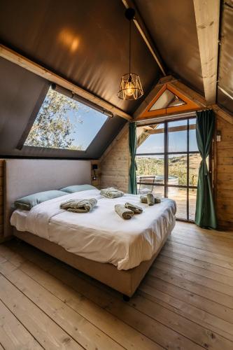 a large bed in a room with a large window at Glamping Uma Casanatura in Cellino Attanasio
