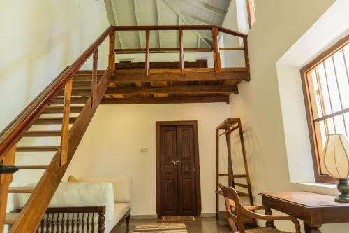 a wooden staircase in a living room with a table at Villa Kobeimalhéna, Matara in Sulutanagoda