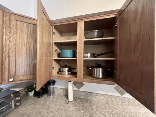 a kitchen with wooden cabinets with pots and pans at Spacious Lake Retreat for Families in Saint Cloud
