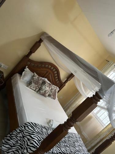 a bedroom with a bed with a canopy at Comfy Apartments in Mombasa