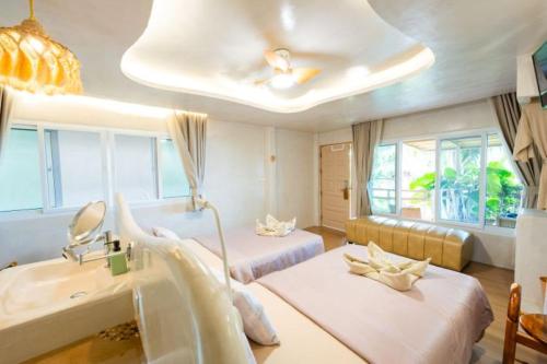 a hospital room with two beds and a sink at The Rock Samui Beachfront Villas - Sha Plus Hotel in Lamai