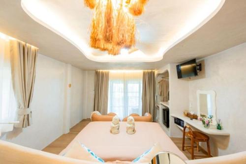 a living room with a bed and a chandelier at The Rock Samui Beachfront Villas - Sha Plus Hotel in Lamai