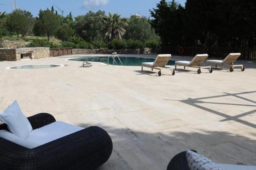 a group of chairs sitting on a patio next to a pool at Mehmet Ali Ağa Konağı in Datca