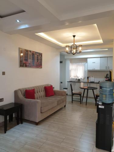 un salon avec un canapé et une cuisine dans l'établissement Blowsuites Furnished Apartment, à Lotus Island