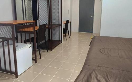 a room with a bed and a table and chairs at ชิตตยาแมนชั่น in Hat Yai
