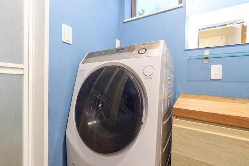 a washing machine in a room with a blue wall at DM Hotel in Tokyo