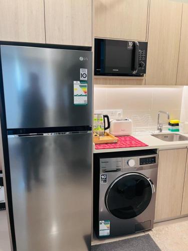 a kitchen with a stainless steel refrigerator and a microwave at Colombo, Trizen Luxury Apartments, Sri Lanka in Colombo