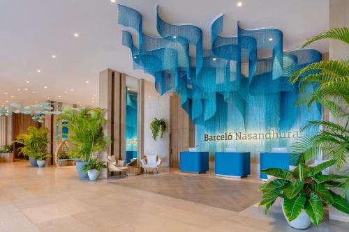 マレにあるBarceló Nasandhura Maleの青い壁のホテルロビー