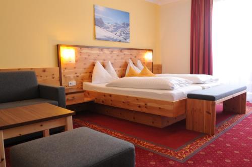 a hotel room with a bed and a chair at Hotel Erlebniswelt Stocker in Schladming