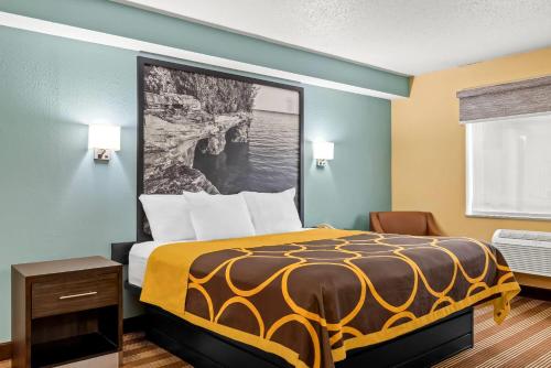 a bedroom with a bed with a yellow and black comforter at Super 8 by Wyndham Osseo WI in Osseo