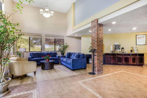 a living room with blue couches and a brick pillar at Baymont by Wyndham Cortez in Cortez