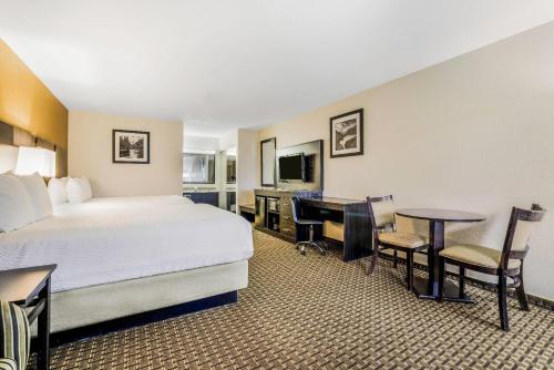a hotel room with a bed and a desk at Baymont by Wyndham Cortez in Cortez
