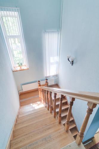 an empty room with a wooden staircase with two windows at Cottage New Sakramulo in Karsimaantkari