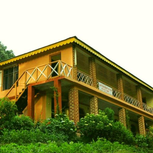 a large yellow building with a balcony on it at The Velvet Pine in Chamba