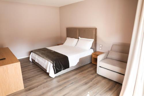 a bedroom with a white bed and a couch at Hotel Platinium Dhermi in Vlorë