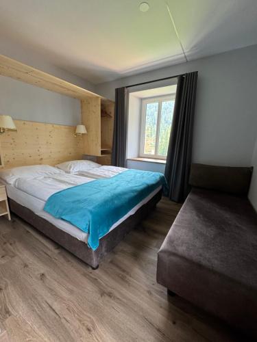 a bedroom with a large bed and a window at Glacier Rock guesthouse ex Pension Dangl in Solda