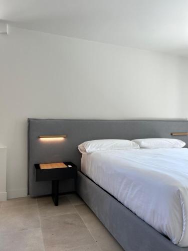 a bed with a gray headboard with a night stand at Arume Rural House in Catasueiro