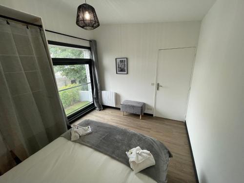 a bedroom with a bed and a large window at Superbe loft lumineux à Caen, Loft in Caen