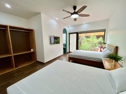 une chambre avec deux lits et un ventilateur de plafond dans l'établissement Euphoria Cat Ba Homestay, à Cat Ba