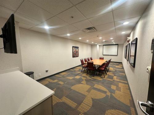 a conference room with a table and chairs and a screen at Home2 Suites by Hilton Rahway in Rahway