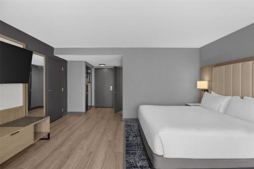 a bedroom with a large white bed and a flat screen tv at DoubleTree by Hilton Las Vegas Airport in Las Vegas