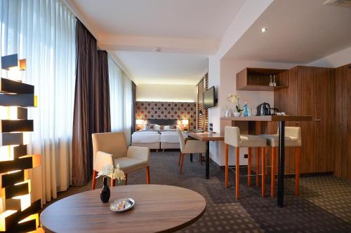 a hotel room with a bed and a living room at Best Western Hotel Hohenzollern in Osnabrück