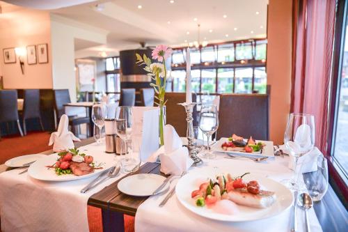 a table with plates of food on it in a restaurant at Best Western Hotel Hohenzollern in Osnabrück