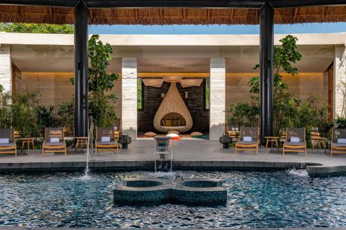 a resort with a fireplace and a swimming pool at Conrad Tulum Riviera Maya in Tulum