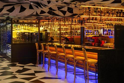 a bar with a bunch of chairs sitting at it at Hilton Garden Inn Asuncion Aviadores Del Chaco in Asuncion