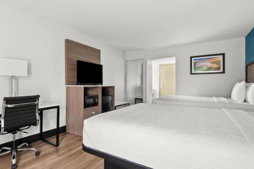 a hotel room with a bed and a flat screen tv at Baymont by Wyndham Batavia - Darien Lake in Batavia