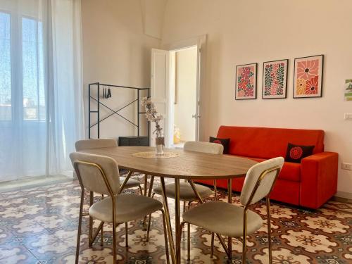 un soggiorno con un tavolo e un divano rosso di Casa Vacanze White Palace ad Alliste