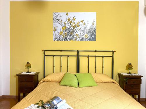 a bedroom with a bed with green pillows on it at Azienda Agrituristica Bergi in Castelbuono