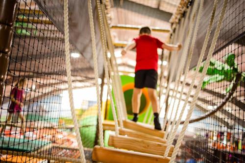a man walking down a rope swing in a playground at Thermenhotel Kurz in Lutzmannsburg