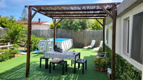 a patio with a table and chairs under a pergola at villa mina con vasca idromassaggio in Taranto