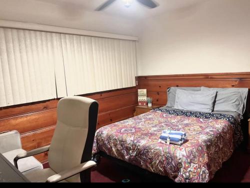 1 dormitorio con 1 cama y 1 silla junto a la cama en Room in Monterey Park CA, en Monterey Park