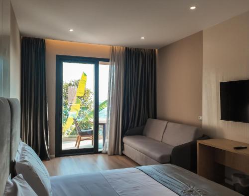 a hotel room with a bed and a couch at Hotel Platinium Dhermi in Vlorë