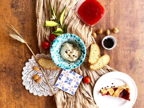 a table with a plate of food and a bowl of dip at Azienda Agrituristica Bergi in Castelbuono