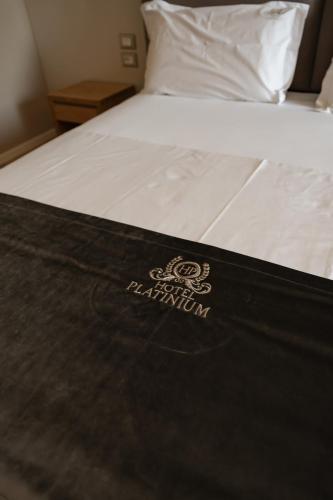 a bed with a sign on the side of it at Hotel Platinium Dhermi in Vlorë