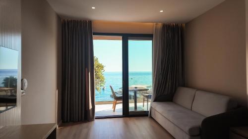 a living room with a couch and a view of the ocean at Hotel Platinium Dhermi in Vlorë