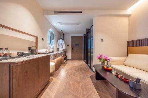 a living room with a couch and a kitchen at Yi Nian · Fangcun Hotel in Nanchang
