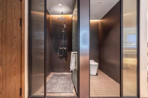a glass shower in a bathroom with a toilet at Yi Nian · Fangcun Hotel in Nanchang
