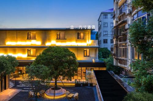a building with a tree in front of it at Yi Nian · Fangcun Hotel in Nanchang
