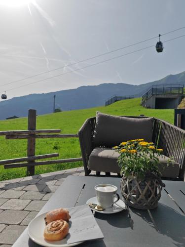 a table with a cup of coffee and a plate of food at ZAGLGUT HOTEL-CHALETS Wellness & Views with Summer Card Included in Kaprun