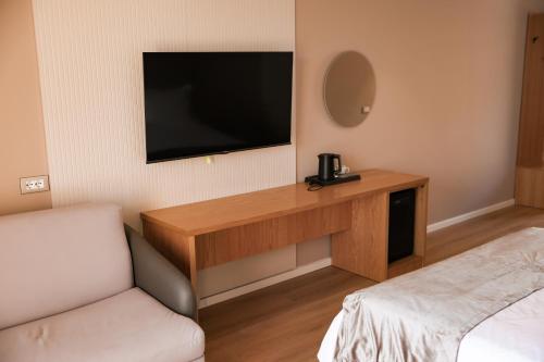 a hotel room with a television and a bed at Hotel Platinium Dhermi in Vlorë