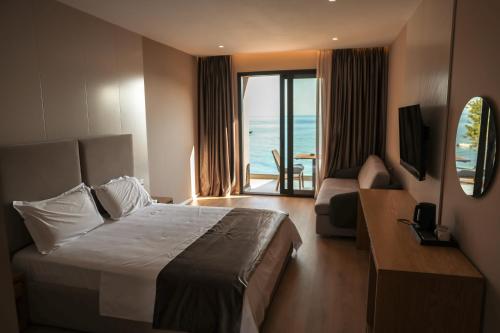 a hotel room with a bed and a view of the ocean at Hotel Platinium Dhermi in Vlorë