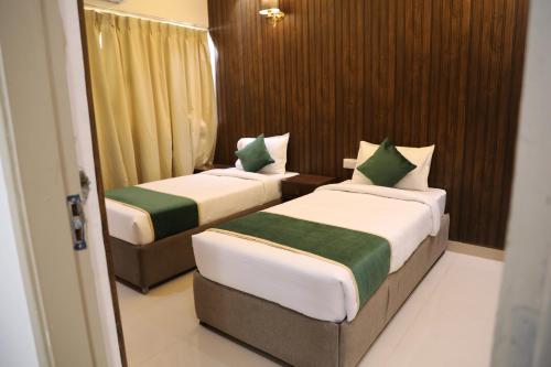 two beds in a hotel room with at Outstay Executive Apartments in Navi Mumbai