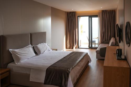 a hotel room with a bed and a living room at Hotel Platinium Dhermi in Vlorë
