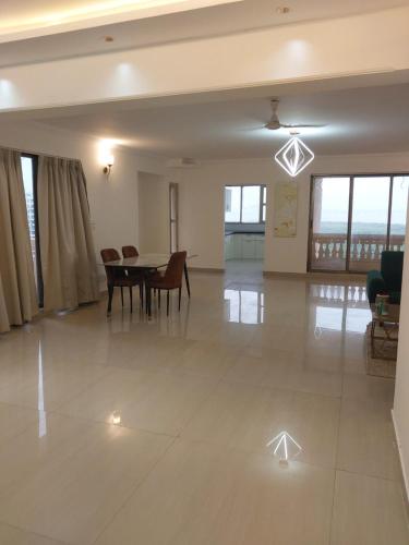 a large living room with a table and chairs at Outstay Executive Apartments in Navi Mumbai