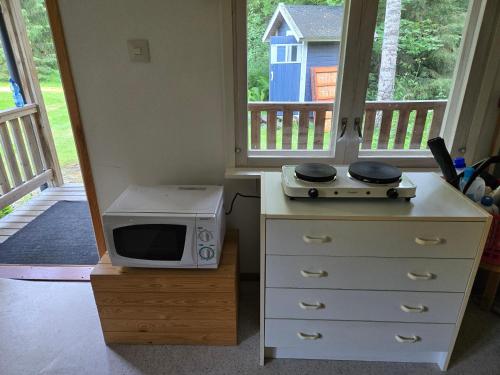 a microwave sitting on top of a dresser with a stove at Merikarviantupa in Pori